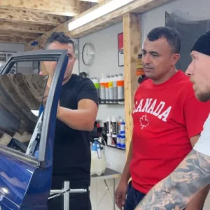 Instructeur et stagiaires analysant la pose d'un film solaire sur une portière.