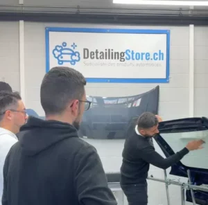 Démonstration de pose de film teinté sur une lunette arrière en atelier.