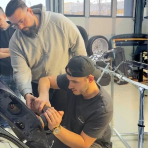 Instructeur guidant un stagiaire sur l'utilisation d'une polisseuse.