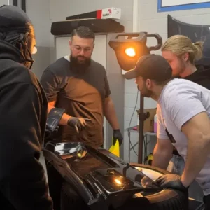 Stagiaire apprenant à appliquer un traitement céramique sur carrosserie lors d'une formation detailing.